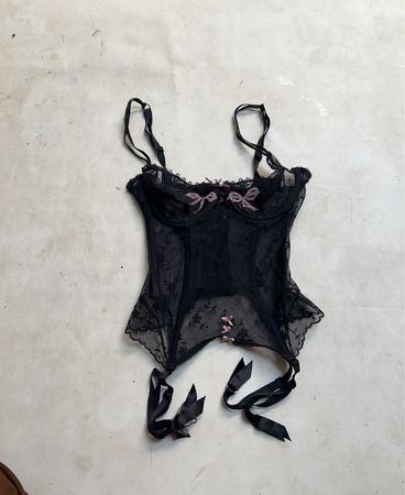 Schwarzer Spitzenkorsett mit rosa Schleifen