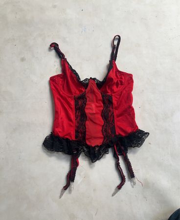 Rotes und schwarzes Spitzenkorsett mit Strapsen