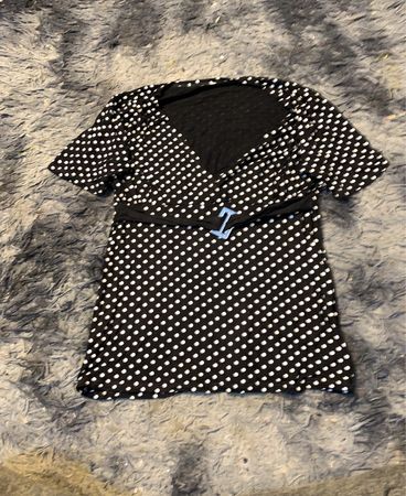 Schwarzes und weißes Punkte-T-Shirt mit kurzen Ärmeln und blauen Schnallendetails