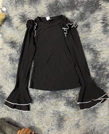 Schwarzes Langarmshirt mit Rüschenschultern und Glockenärmeln