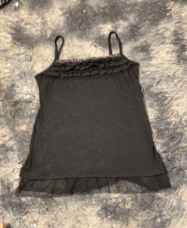 Schwarzes Trägershirt mit Rüschen und Spitze.