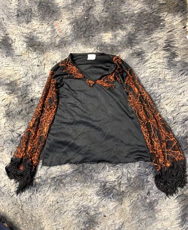 Schwarzes Oberteil mit orangen Spitzenärmeln und Fransen