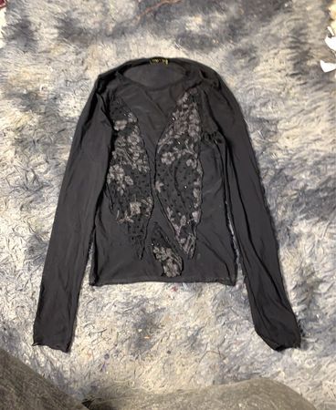 Schwarzes Langarmoberteil mit transparenten Paneelen und verzierte Details