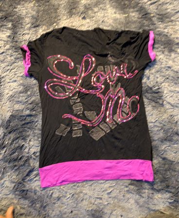 Schwarzes T-Shirt mit "Love Me" Pailletten-Design und pinkem Trim.