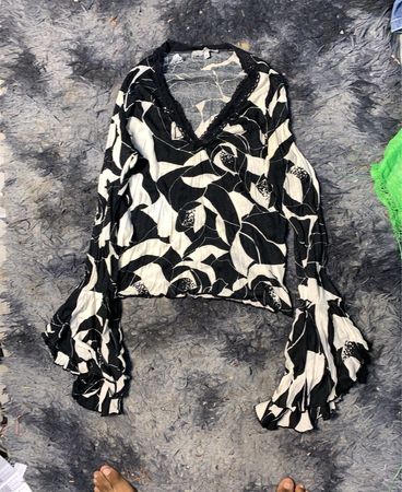 Schwarz-weiße Bluse mit Blumenmuster und Glockenärmel