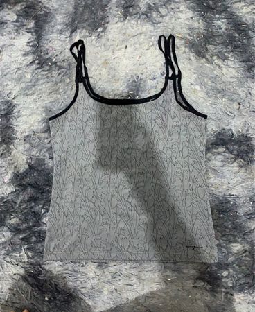 Graues Top mit schwarzem Saum und Blattmuster