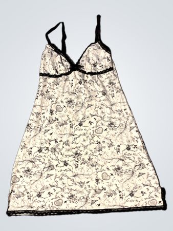 Weißes Nachthemd mit schwarzem Spitzenbesatz und einem schwarzen Blumenmuster.