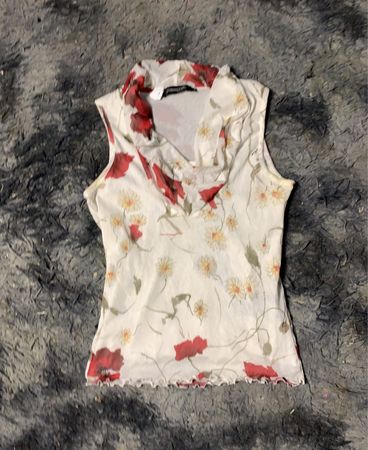 Weißes ärmelloses Top mit floralem Druck von roten Mohnblumen und Gänseblümchen.