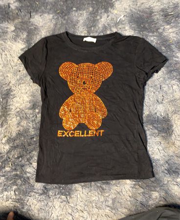 Schwarzes T-Shirt mit Pailletten-Bären und dem Text "EXCELLENT