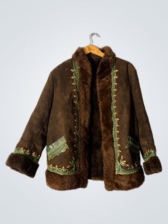 Veste en daim brun avec garniture brodée et manches en fourrure.