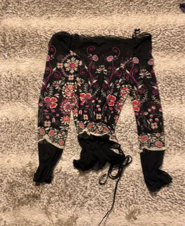 Schwarzes, durchsichtiges Oberteil mit floralen Motiven und langen Ärmeln sowie Bindedetail.