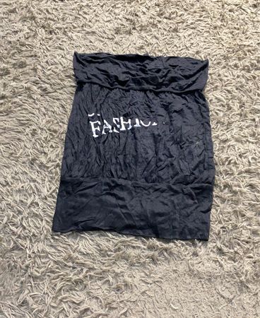 Schwarzes, trägerloses Oberteil mit "FASHION" auf der Vorderseite bedruckt.