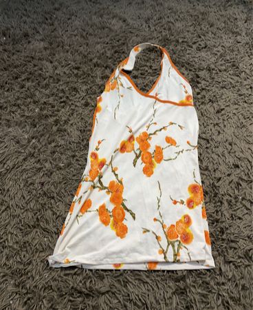 Weißes Haltertop mit orangefarbenem Blumenmuster