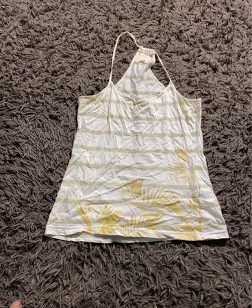 Weißes Tanktop mit goldenen Streifen und Grafik eines Palmblatts