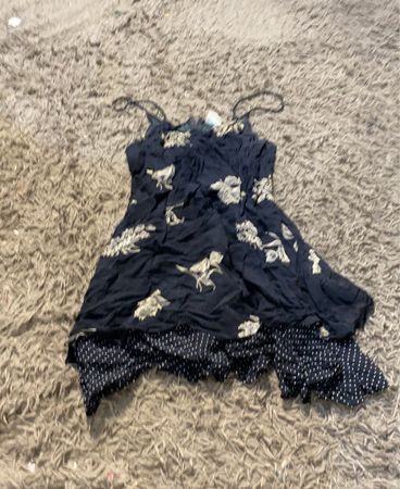 Schwarzes Kleid mit weißem Blumendruck und gepunktetem Rock