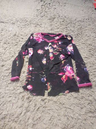 Schwarzes Langarmhemd mit floralem Druck und pinkem Saum.