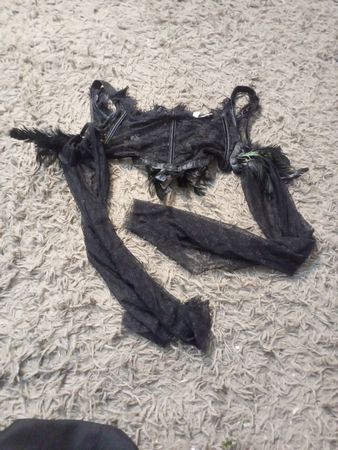 Corset en dentelle noire avec des accents en plumes et des manches transparentes
