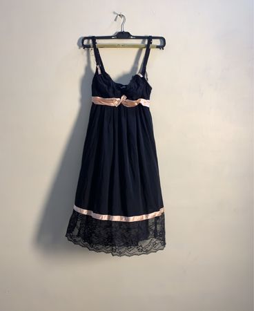 Schwarzes Slipkleid mit pinkem Bogen und Spitzenbesatz
