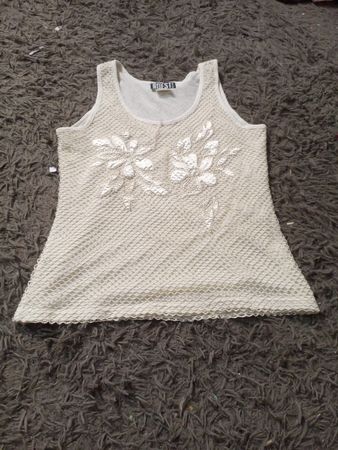 Einfach das beste cremefarbene Tanktop mit floralem Schmuck.