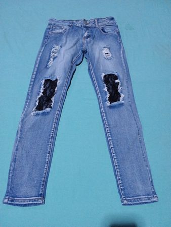 Blaue verwaschene Jeans mit schwarzen Spitzeneinsätzen