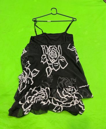 Schwarzes Kleid mit weißem Blumenmuster und gestuften Rüschen