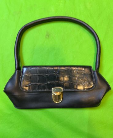 Schwarze Handtasche mit Krokodilprägung auf der Klappe
