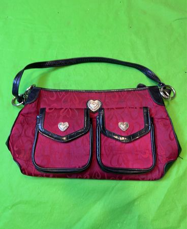 Rote Handtasche mit schwarz gemustertem Rand und zwei Vordertaschen