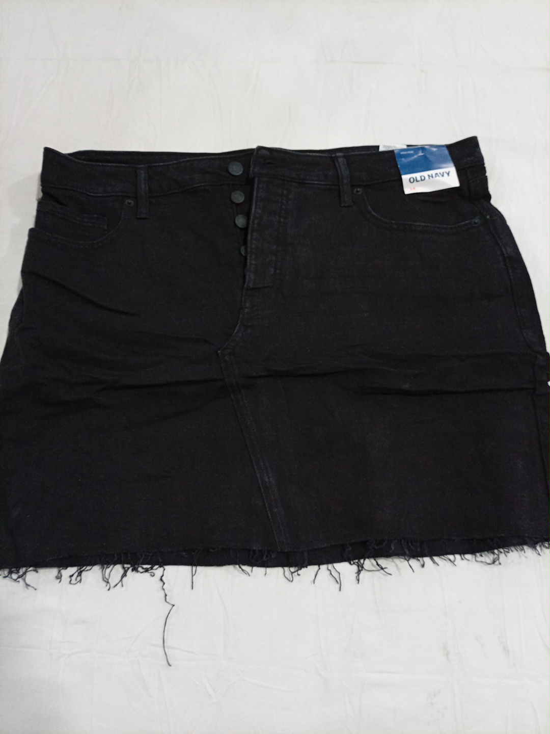 Jupe en jean mini noire déchirée à boutons devant ..