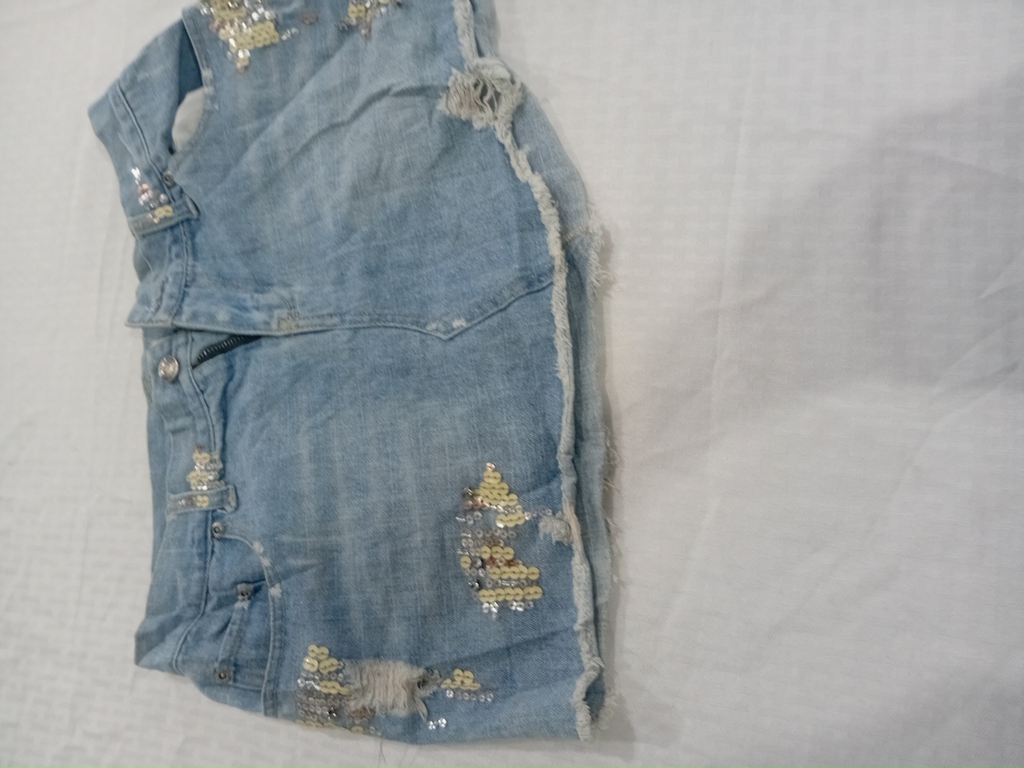 Mini jupe en denim embellie déchirée par Angel Kis..