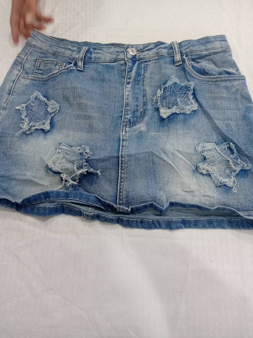 Jupe mini en denim bleu déchiré avec des patches e..