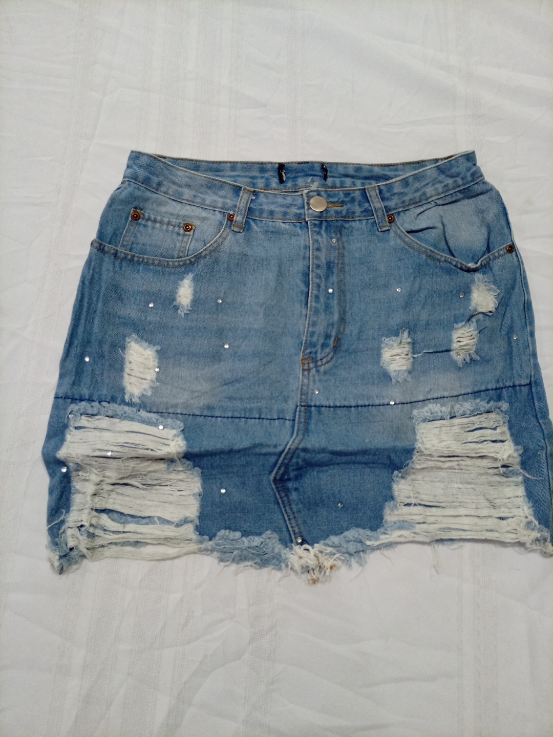 Mini-jupe en jean déchirée taille haute avec des s..