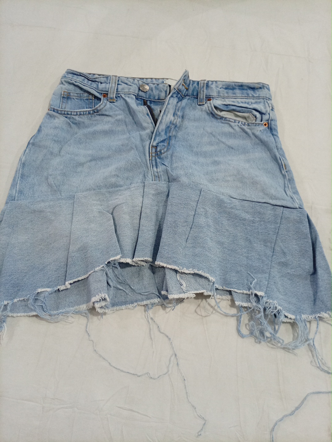 Jupe en denim clair H&M avec ourlet évasé et bords..