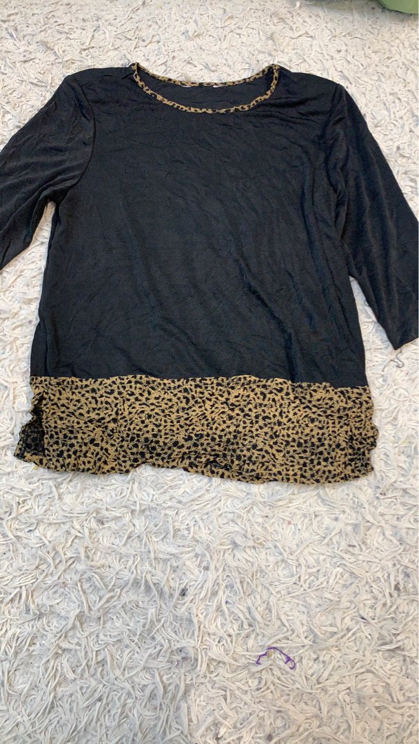 Schwarzes Langarmoberteil mit Leopardenmusterbesat..