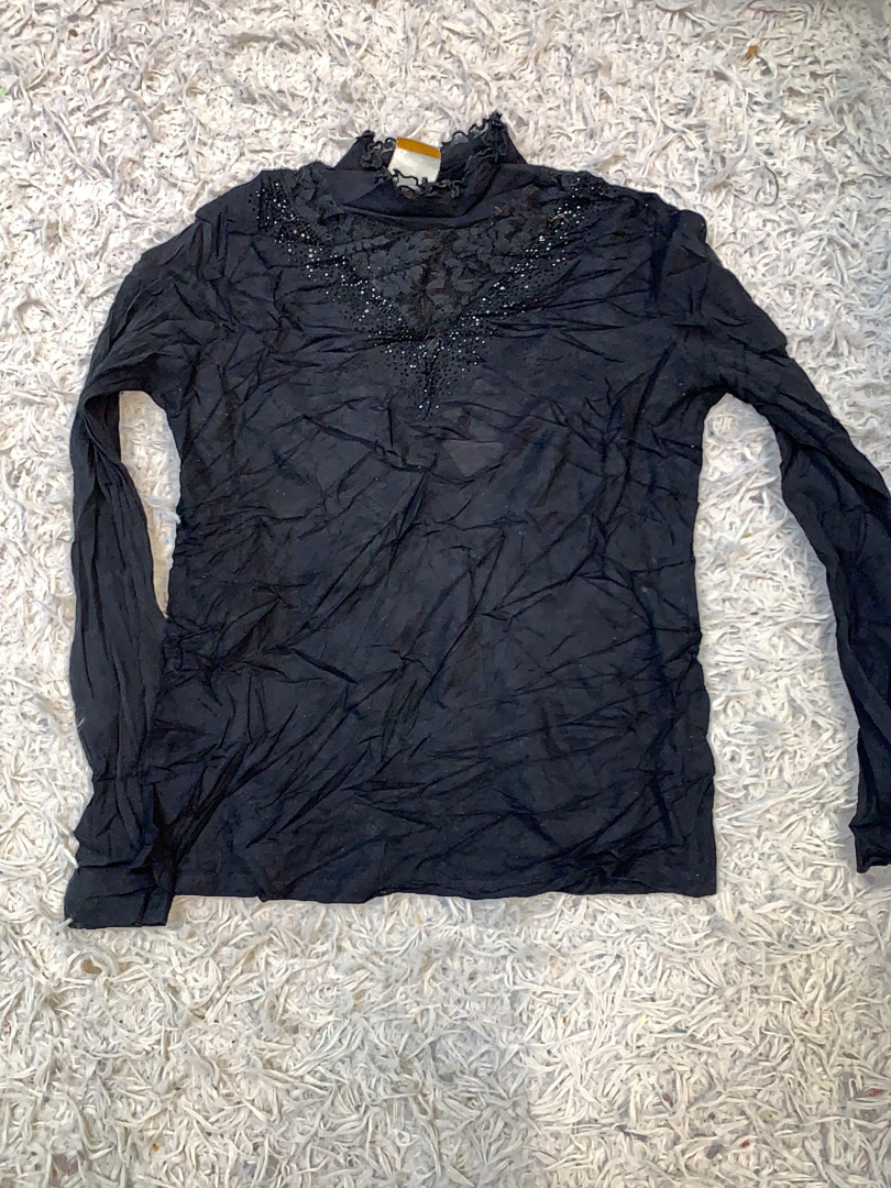 Schwarzes Langarmoberteil mit besticktem Ausschnit..