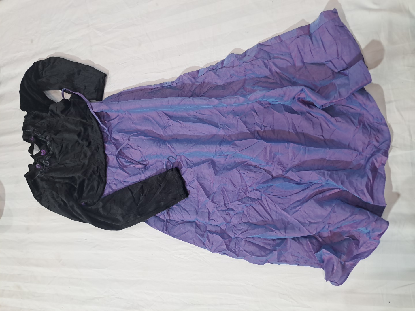 黒の長袖トップと紫のスカート