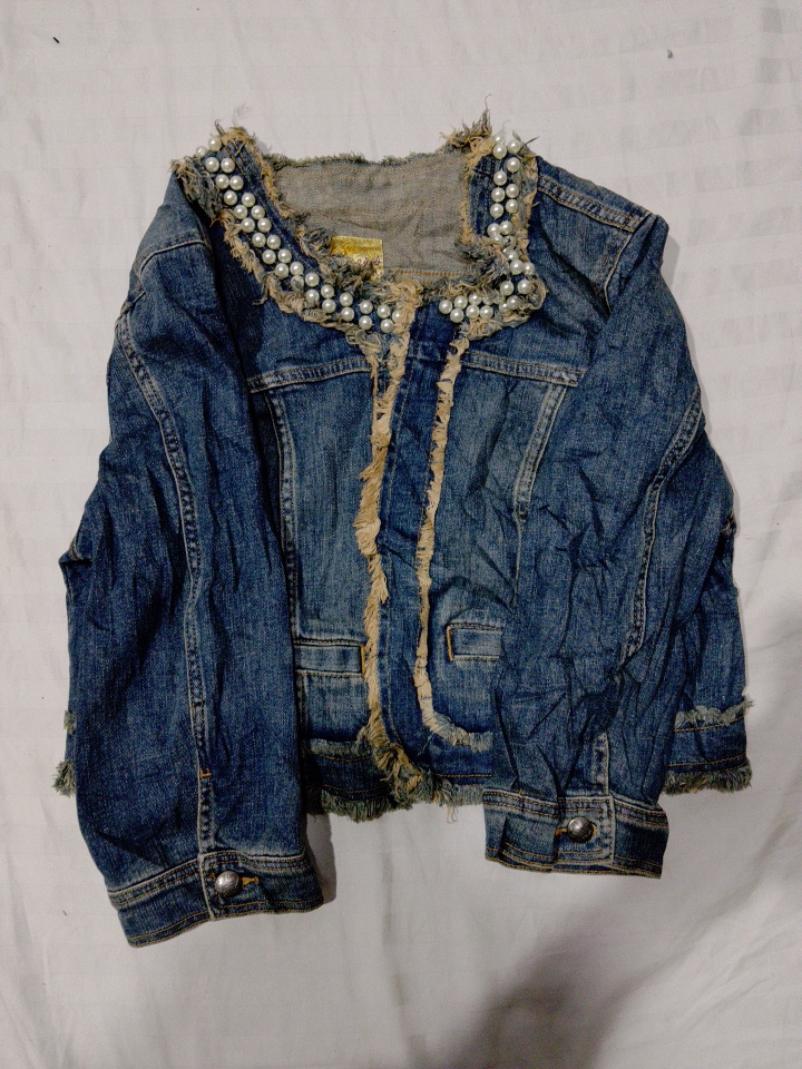 Abgewetzte Denimjacke mit Perlenverzierungen