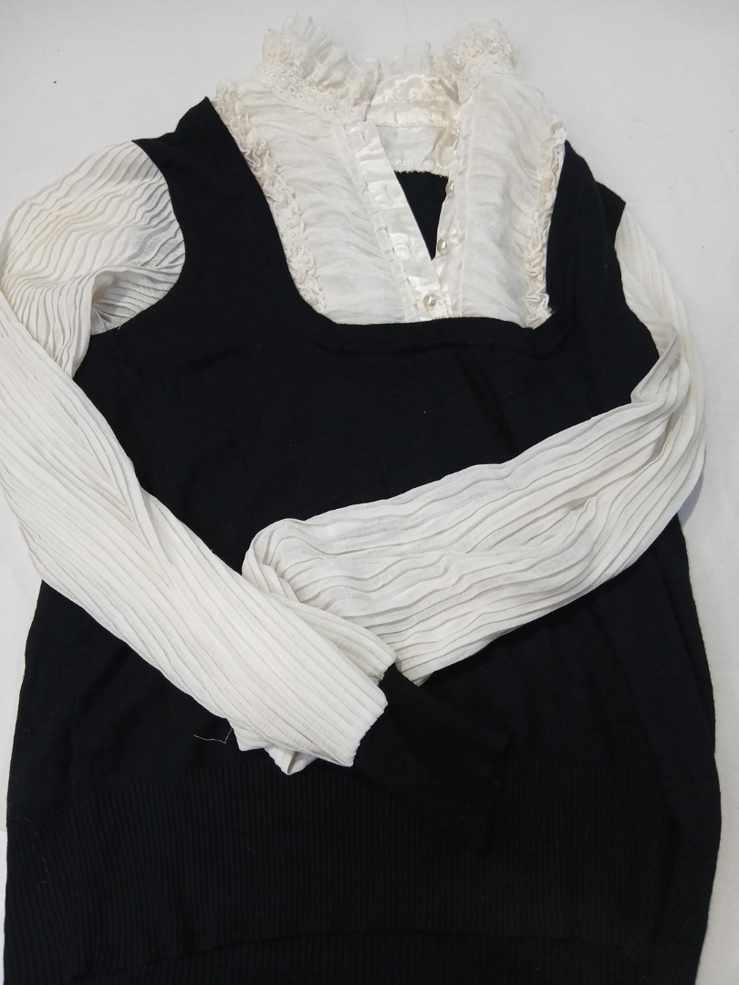 Top a maglia bianco e nero con colletto a volant