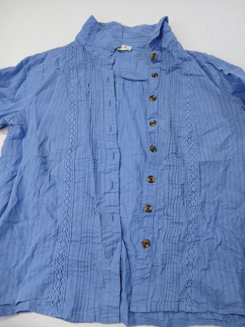 レースのディテールがある青いリネンのブラウス