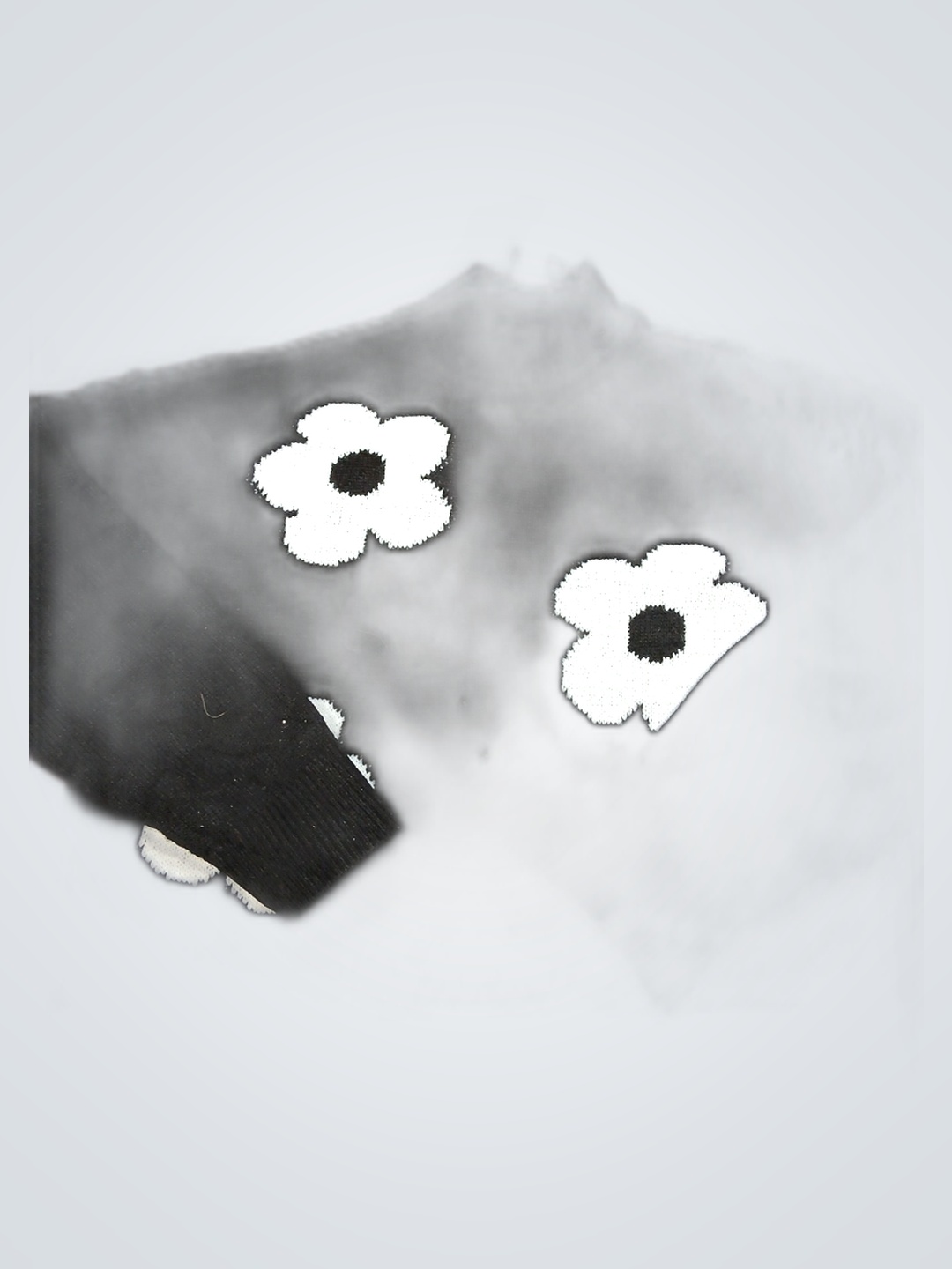 Pull en tricot noir avec des fleurs blanches