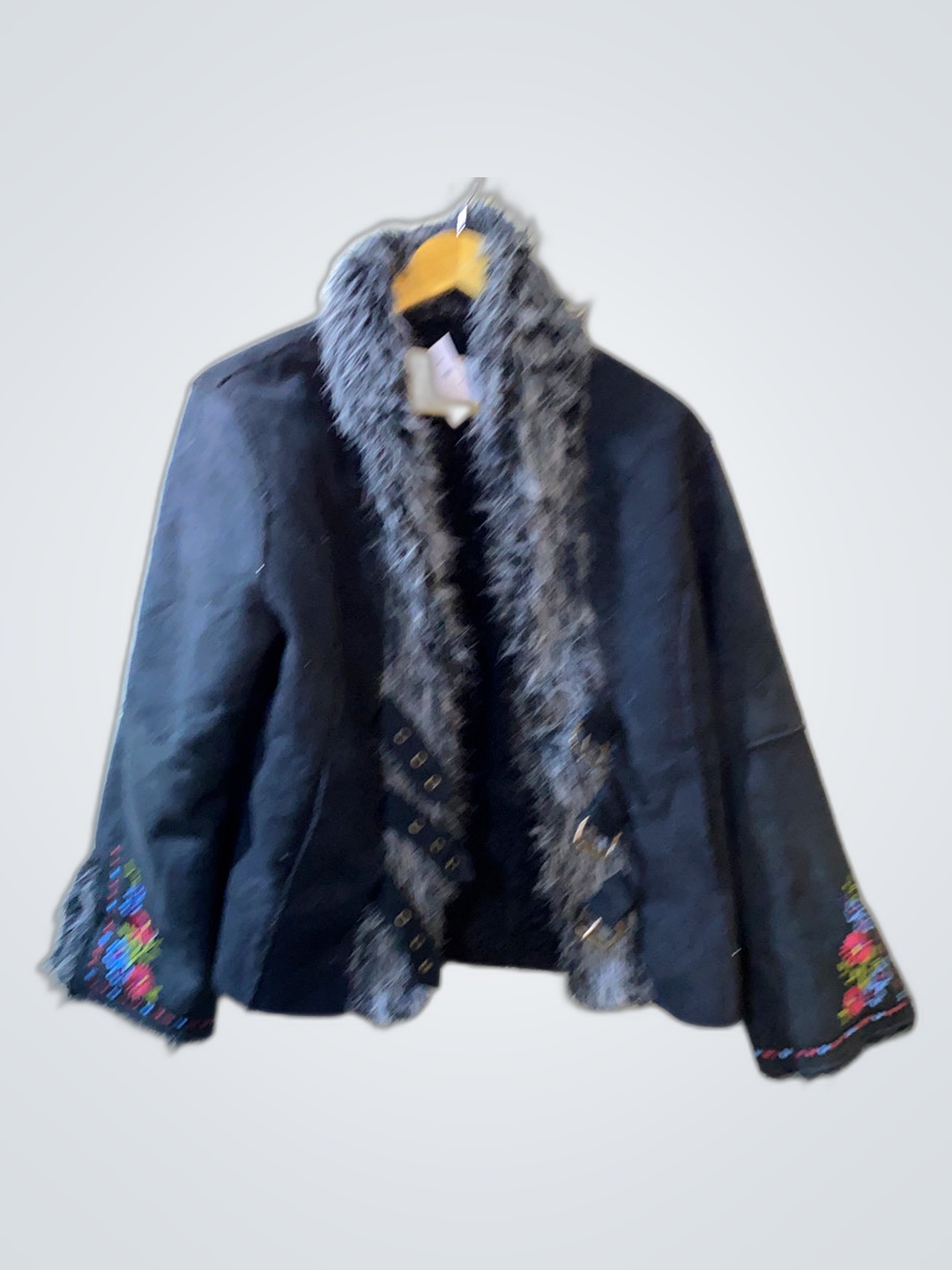 「刺繍入りの袖が付いた黒いファー付きジャケット」